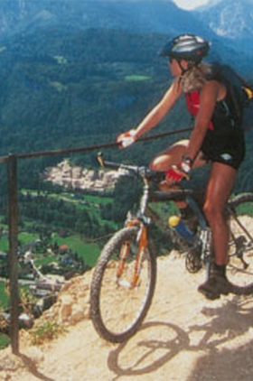 Radfahrerin im Salzkammergut blickt in das Tal hinunter